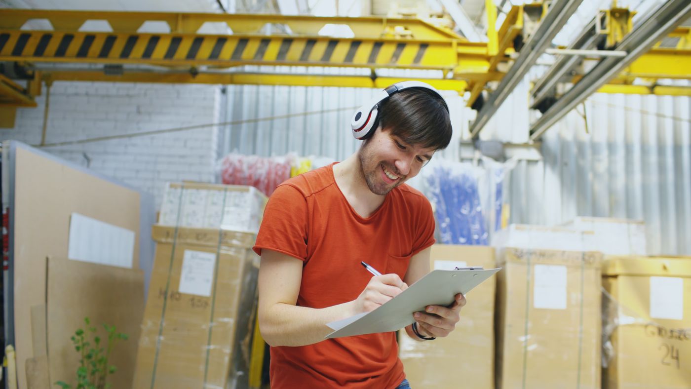 Warehouse worker checking paperwork on a clipboard