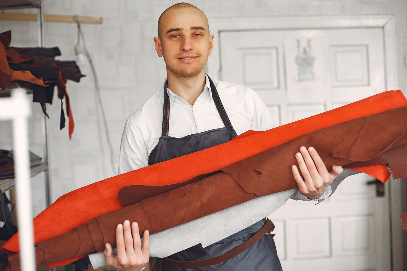 Workshop owner among rolls of fabric