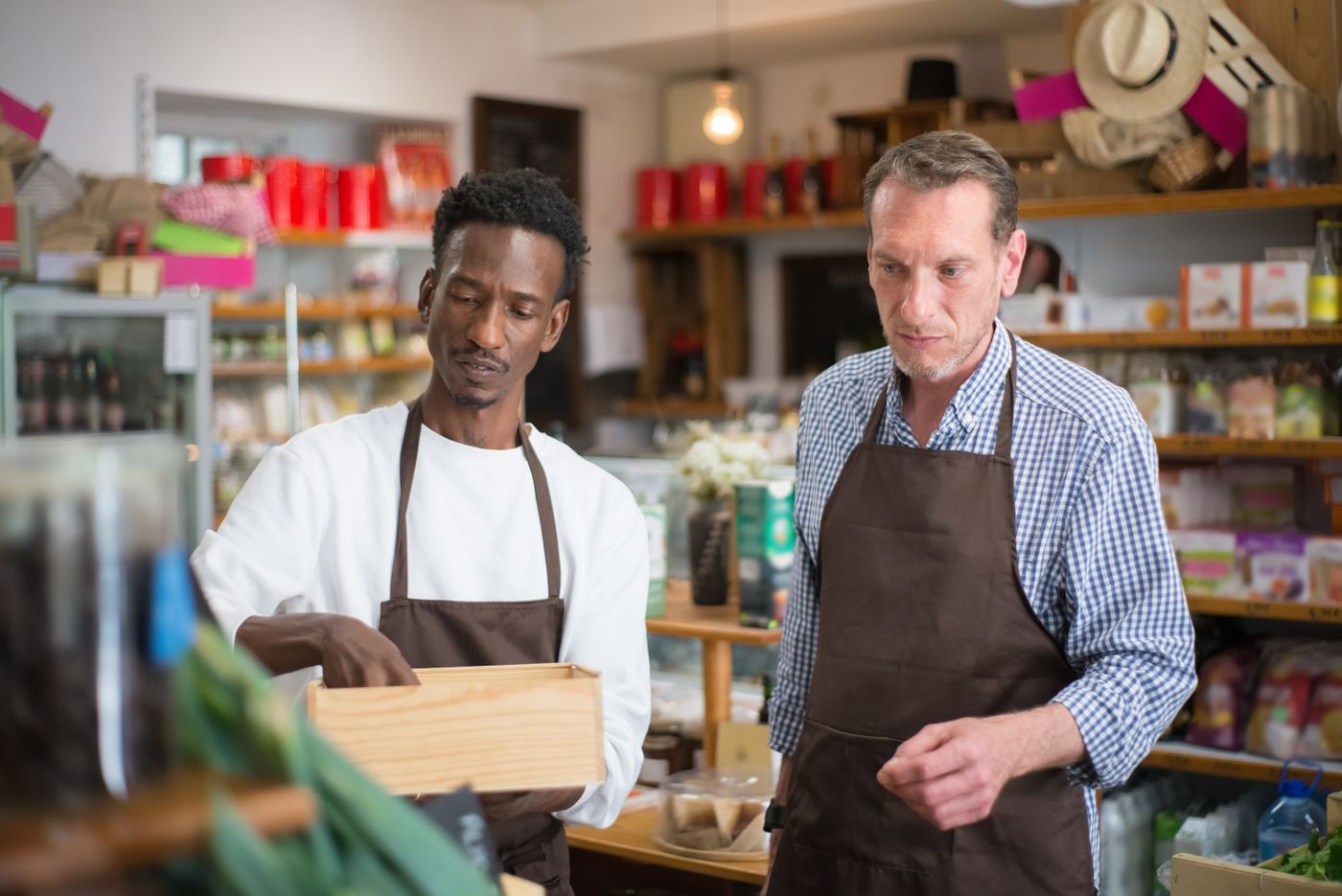 Two staff members organising stock on the shelves of a grocery store